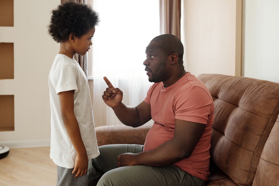 Father and son engaged in a heartfelt conversation on the sofa, illustrating parenting in a loving family setting.